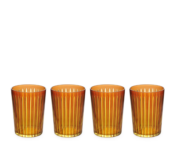 The Prism Highball Set of 4 by L'Objet features amber-colored glasses with vertical ribbed patterns. These stylish, dishwasher-safe tumblers are arranged in a row against a white background, combining elegance and convenience for everyday use.