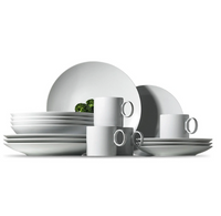 The Loft Everyday White Dinnerware by Thomas For Rosenthal, featuring plates, rimless soup bowls, and mugs with round handles, is neatly stacked on a white surface in a minimalistic arrangement with clean lines.