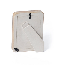 The Valari Burl Veneer Frame by Zodax features natural wood, a beige suede-like stand, and two black hooks for vertical or horizontal display.