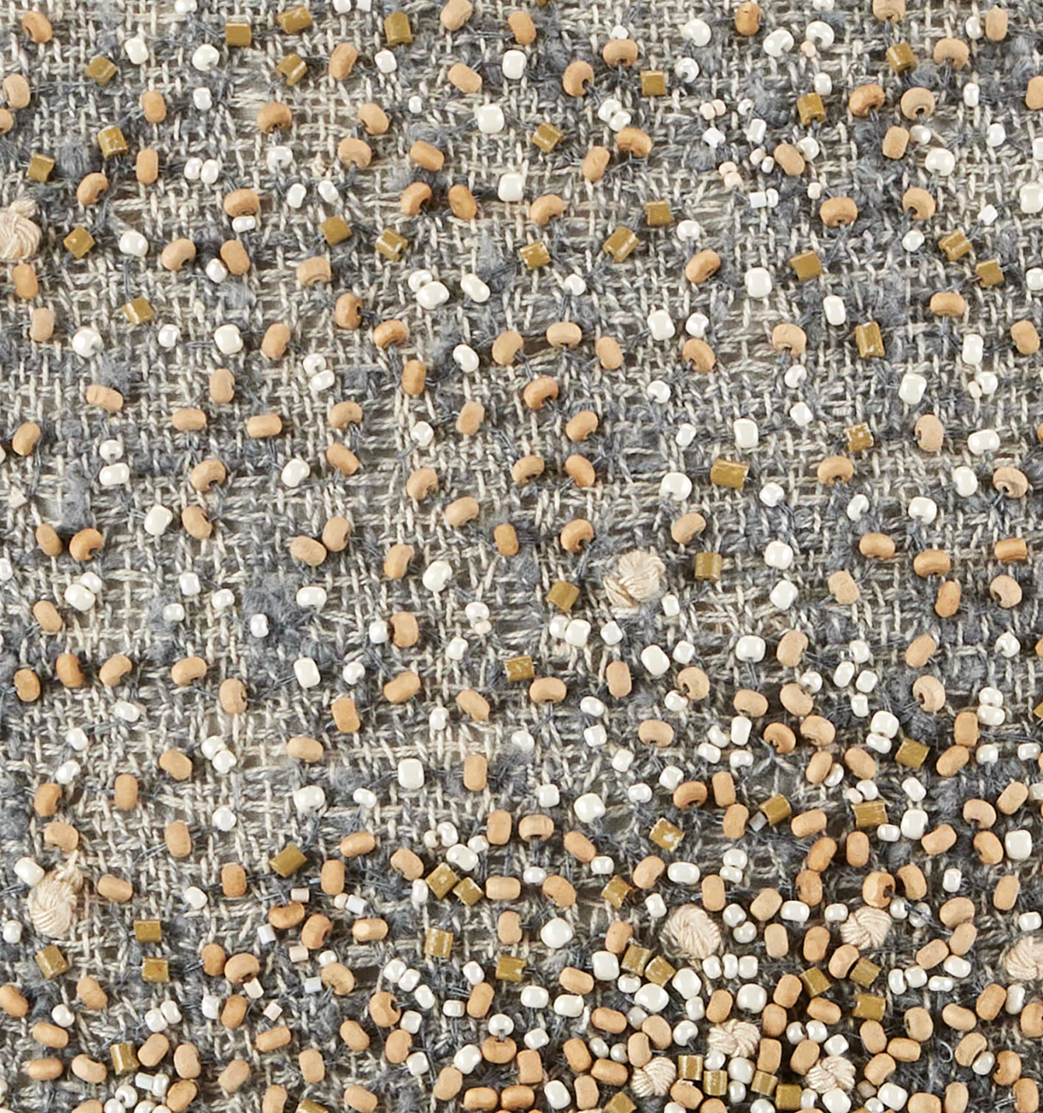 A close-up of the Bead Burst Pillow Azure 22 x 22 by Threads Soft Goods reveals artisanal craftsmanship: a woven gray jacquard base adorned with tan, white, and olive beads creates a richly textured decorative pillow surface.