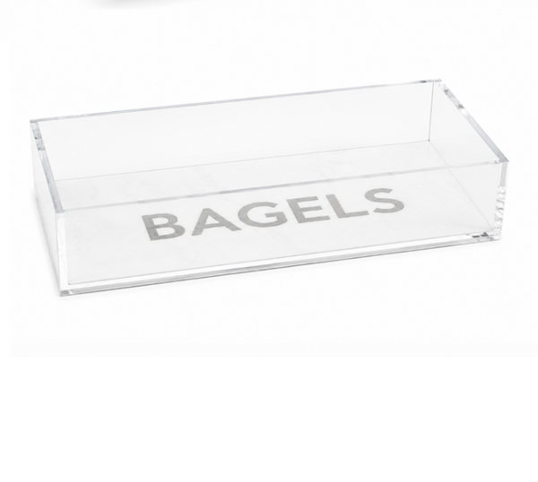 Introducing the Eye Candy Bagel Tray: a clear, rectangular acrylic container featuring the word “BAGELS” in bold gray letters on the bottom. This food-safe tray from Eye Candy makes an ideal gift for any bagel lover.