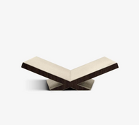 The Assouline Culture Bookstand - Stone features a modern, V-shaped design with a beige top and dark walnut sides, showcasing geometric angles and minimalist style, set against a plain white background.