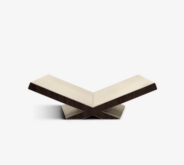 The Assouline Culture Bookstand - Stone features a modern, V-shaped design with a beige top and dark walnut sides, showcasing geometric angles and minimalist style, set against a plain white background.