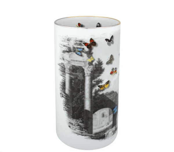 Experience the striking Large Forum Vase by Christian Lacroix, a tall cylindrical luxury porcelain piece from Vista Alegre featuring black-and-white scenes of ancient ruins and trees, elegantly accented with vibrant butterflies in red, yellow, blue, and orange gliding across its surface.