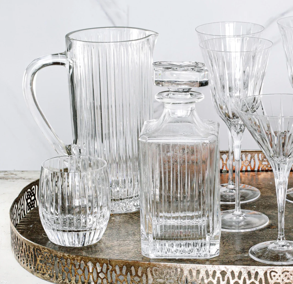 A decorative tray holds Vietri's Natalia Pitcher, a square decanter with stopper, a round tumbler, and stemmed glasses—all featuring matching vertical stripes.