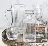 A decorative tray holds Vietri's Natalia Pitcher, a square decanter with stopper, a round tumbler, and stemmed glasses—all featuring matching vertical stripes.