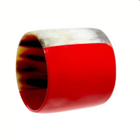 The Horn Napkin Ring Set of 4 by Von Gern Home features wide, smooth rings with bold glossy red accents and marbled natural horn patterns in shades of brown, cream, and white.