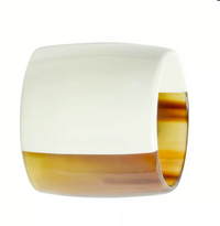 The Horn Napkin Ring Set of 4 by Von Gern Home features wide, chunky rings crafted from natural horn with a glossy, two-tone finish: white on the top half and translucent amber-brown on the bottom.