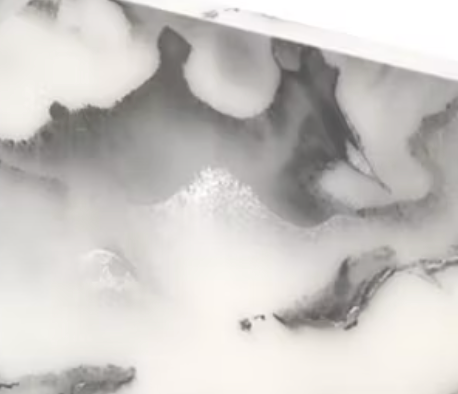 A close-up of the Eye Candy Bagel Tray features a white and gray silver marble acrylic surface with swirling patterns, smooth texture, and a mix of light and dark veining.