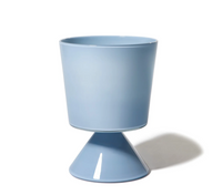 The Cariati Fiorelli Collection Vase - Dove features a modern, light blue ceramic design with a cylindrical top and cone base, ideal for pairing with sculptural glass vases. Shown on a white background with a soft shadow to the right.