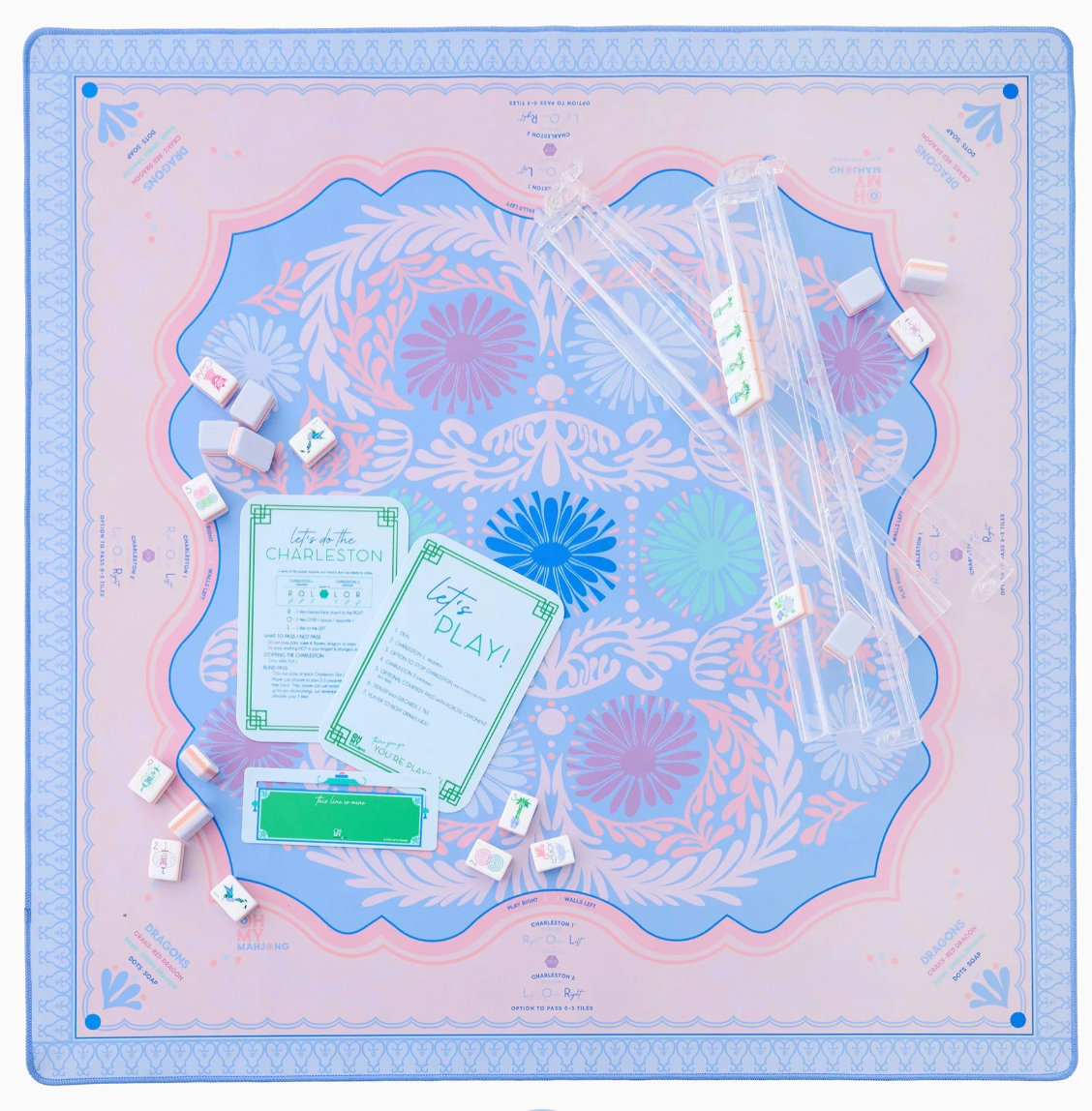The Oh My Mahjong Rack & Pusher Set - Clear includes American Mahjong racks with clear acrylic pushers, shown on a decorative mat with tiles, dice, instruction cards, and other Mahjong accessories.