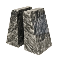 The Zeus Marble Bookend Set by Designs by Marble Crafter features two trapezoidal, black and white marble bookends placed closely together on a white background, adding a sophisticated touch of elegant home decor.