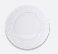 The Bernardaud Louvre Dinnerware features a plain white ceramic plate with a Renaissance-inspired embossed border, shown from above on a light gray background.