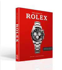 The Book of Rolex by ACC ART BOOKS / SIMON & SCHUSTER is an updated guide with a red cover and silver Rolex watch, featuring details on new models and tips to spot fakes. Essential for Rolex enthusiasts.