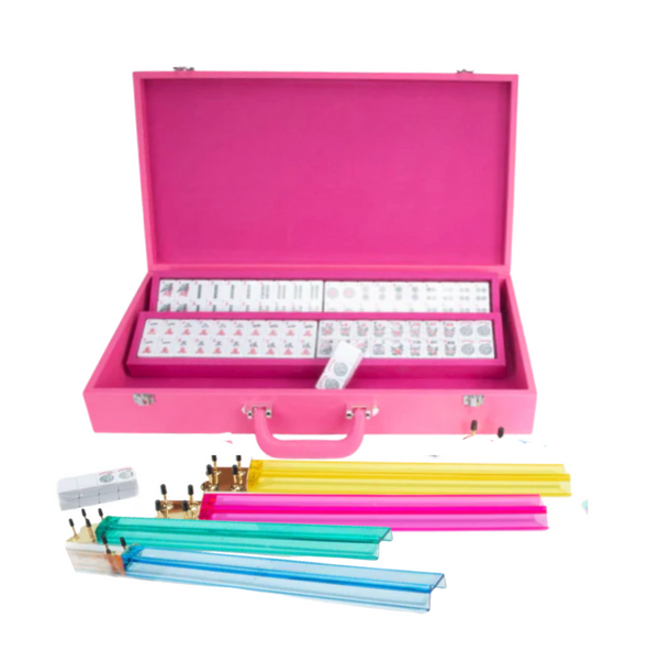 The Ellen Mahjong Set - Pink by Brouk & Co features a pink Saffiano vegan leather case filled with mahjong tiles, colorful betting sticks, dice, and racks—making this portable set both stylish and convenient.