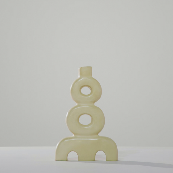 The Aya Vessel - Eggshell by Schwung Design is a modern, handcrafted Moroccan ceramic vase with three stacked circular forms—two with central holes—and two arch cutouts at the base, shown against a plain light background.
