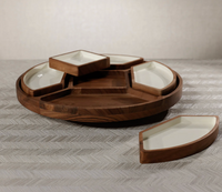 The Zodax Walden 5 Section Lazy Susan is a round wooden tray with five white ceramic wedge dishes, perfect as a stylish condiment organizer on any chevron-patterned surface.
