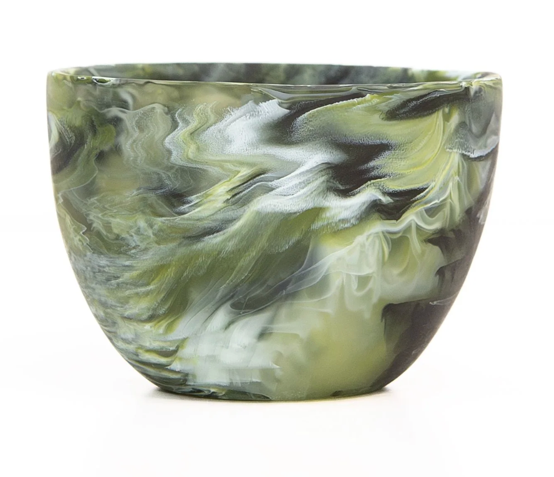 The Nashi Home Swirl Colored Resin Deep Bowl features a hand-crafted marbled green, white, and black pattern and is photographed against a white background.