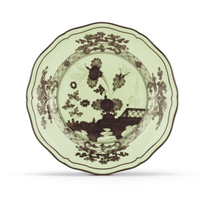 A decorative ceramic plate from the Ginori 1735 Oriente Italiano Dinnerware Bario collection, showcasing a pale green background with dark floral and landscape motifs and a scalloped edge, inspired by classic chinoiserie design.