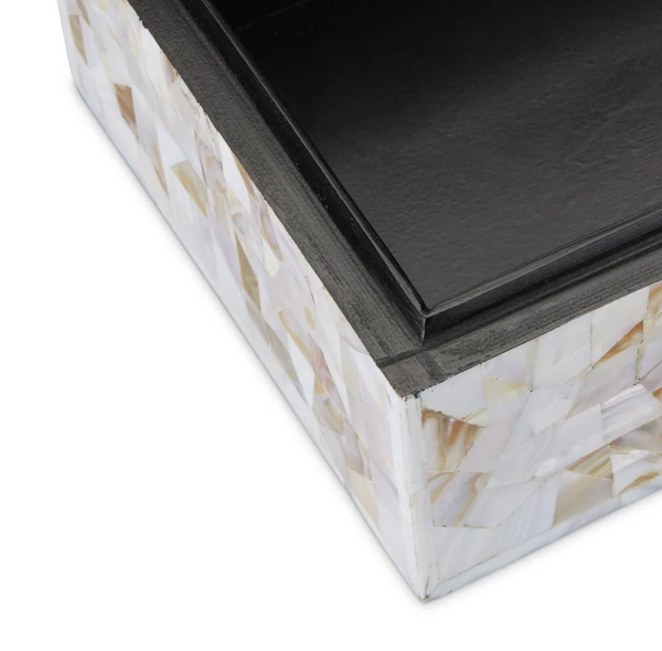 Close-up of the corner of the Simplicity Mother of Pearl Box - Large by Currey & Company, featuring a black lid and a base embellished with a white and beige mother-of-pearl mosaic pattern.