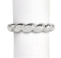 A silver-tone, shell-inspired twisted rope-pattern Jessica McCormack Shell Napkin Ring Set of 4 - Platinum encircling a white cloth napkin.