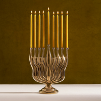 L’Objet Timna Menorah - Bronze with a bronze finish and lit taper candles in each of its nine branches.