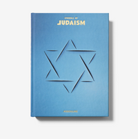 Blue hardcover book titled Symbols of Judaism by Assouline, featuring a die-cut Star of David on the cover and gold-lettered text.