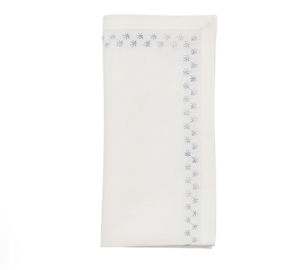 A folded Starry Night Napkin Set of 4 - White & Blue, featuring a blue metallic embroidery star pattern along the edge.