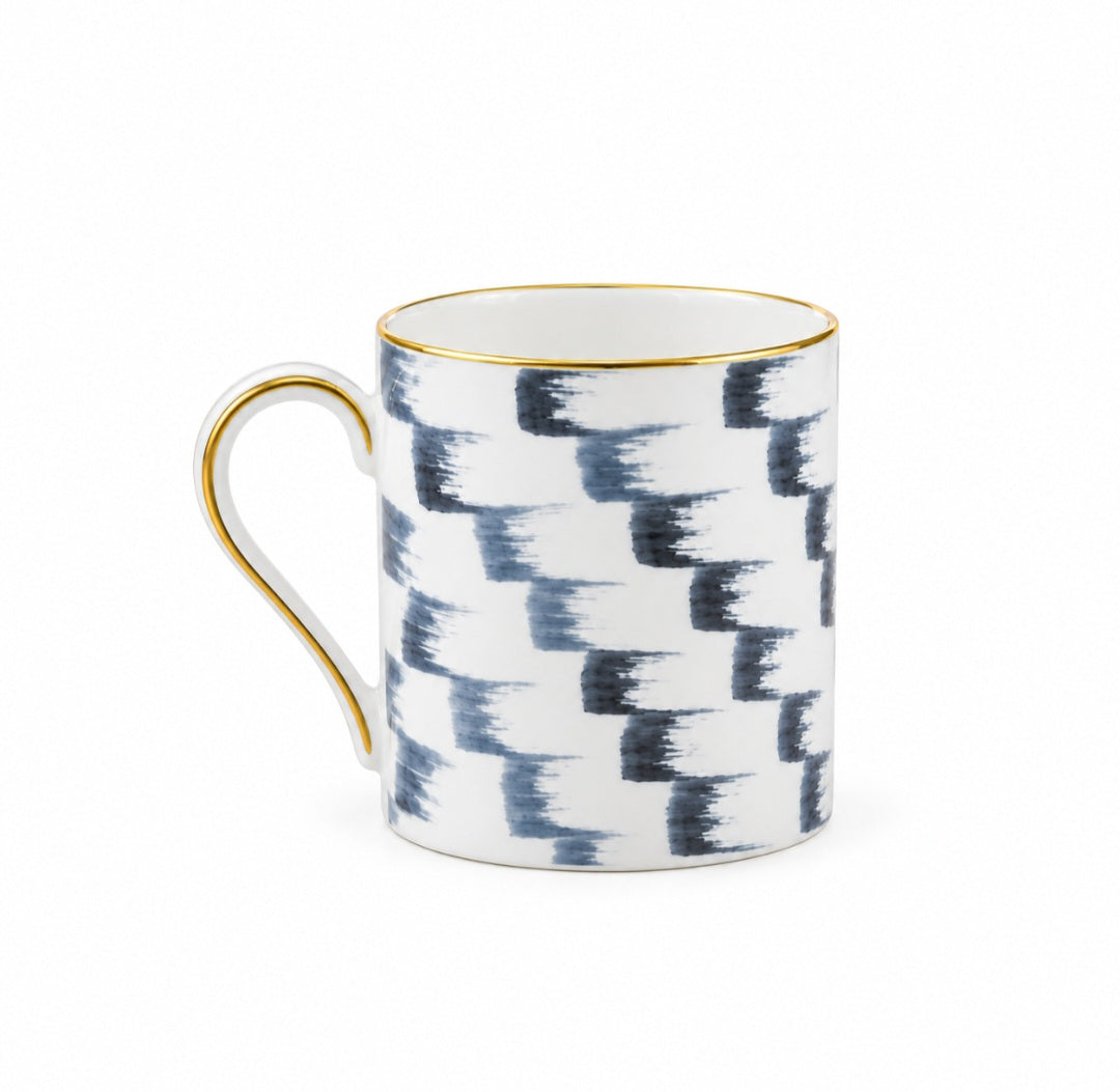 Marie Daâge Panache white hand-painted Limoges porcelain mug featuring a blue, staggered brushstroke pattern with gold trim on the rim and handle.