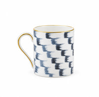 Marie Daâge Panache white hand-painted Limoges porcelain mug featuring a blue, staggered brushstroke pattern with gold trim on the rim and handle.