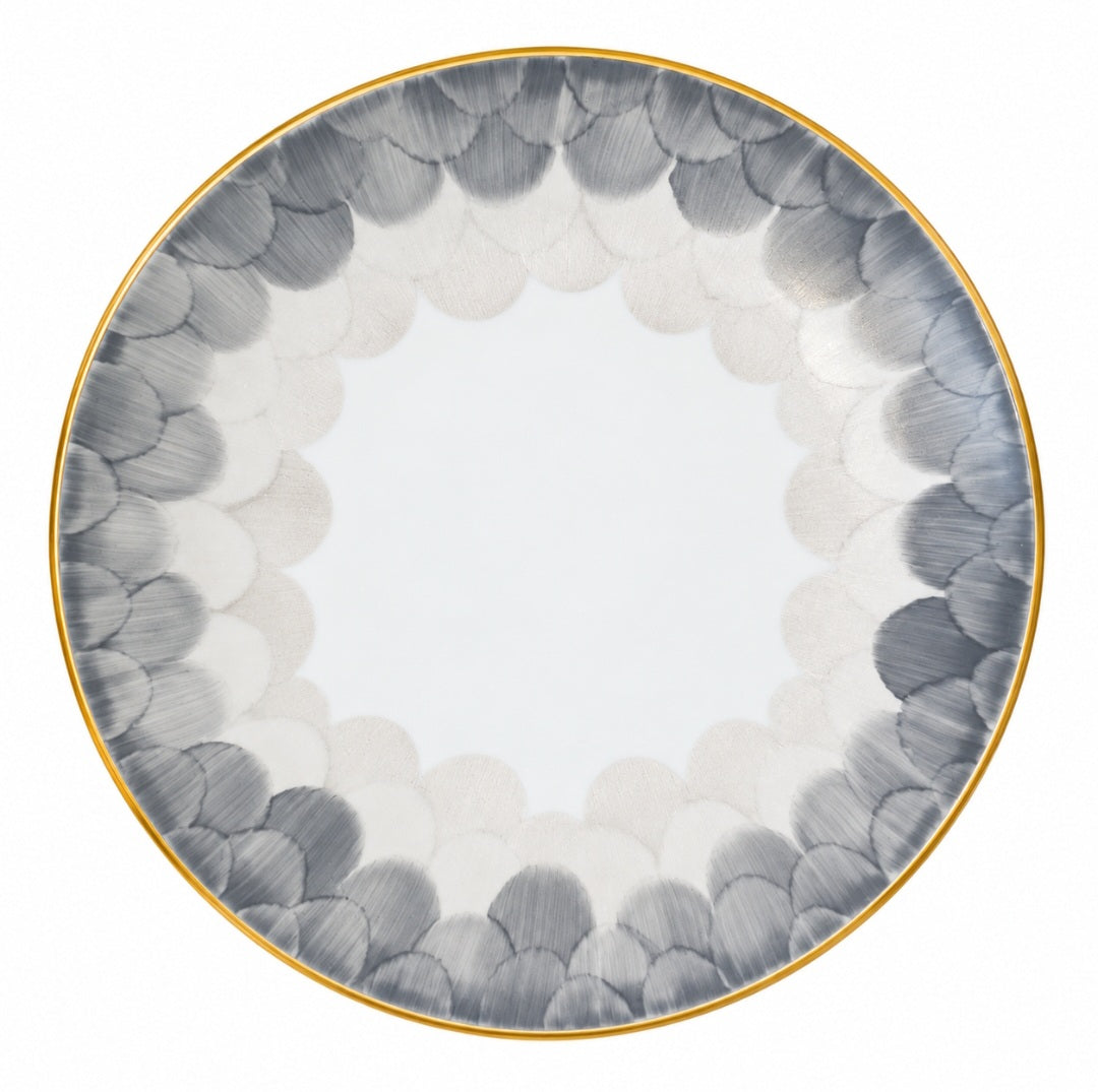 A white Marie Daâge Cercle D’Ecailles Platinum Filet porcelain plate featuring a circular pattern of overlapping grey and light grey scale motifs with a thin gold rim.