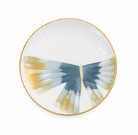 A hand-painted Marie Daage Belle De Nuit 1 porcelain plate featuring a butterfly wing design in blue and gold with a gold rim.