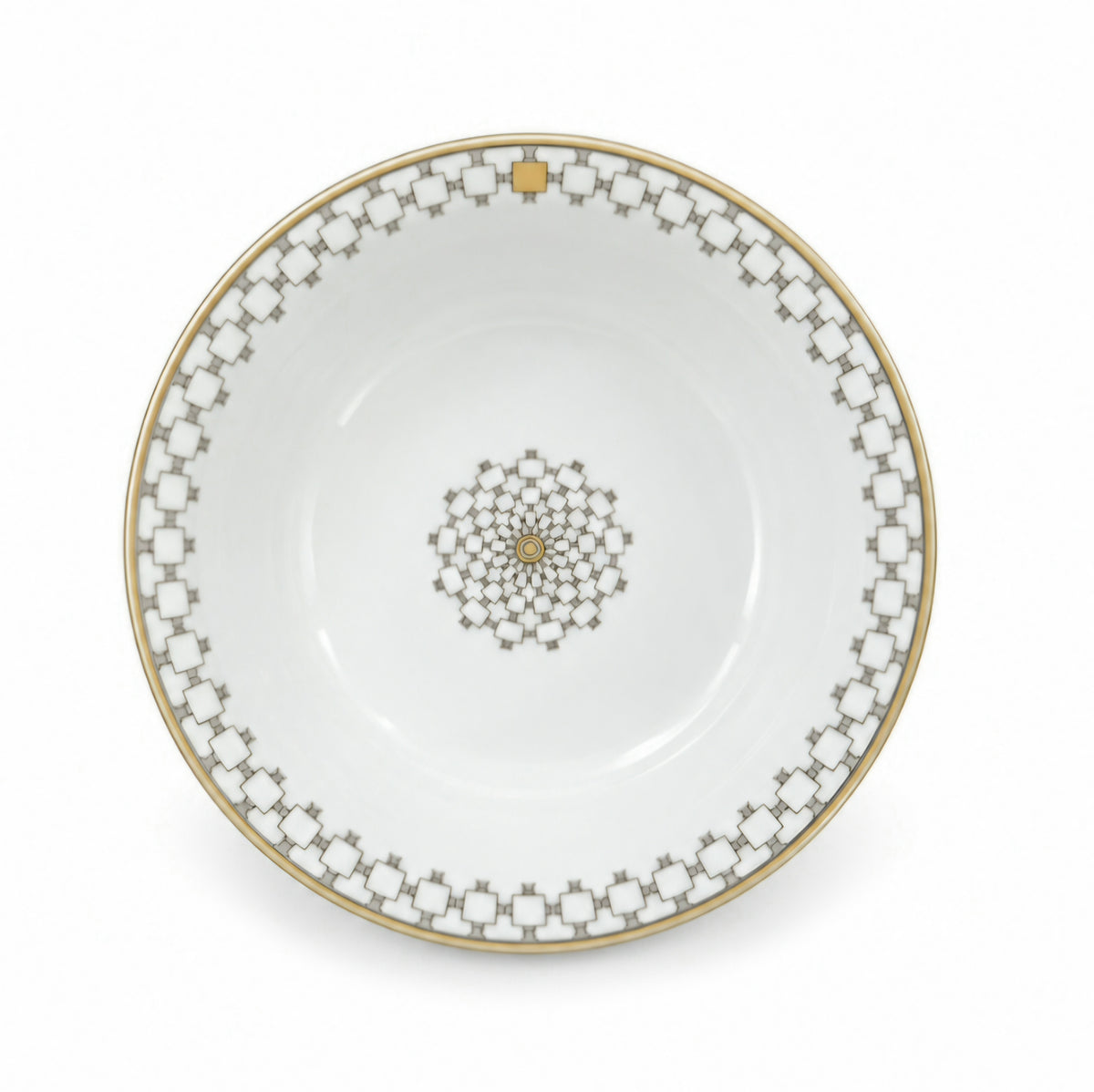A Mottahedeh/Robert Haviland Home Dinnerware- Gold white porcelain bowl with a gold rim and a central geometric medallion pattern.