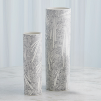 Two tall, cylindrical Searchlight Vases by Global Views/Surya with geometric black-and-white line patterns stand on a light gray surface against a softly blurred light blue background.