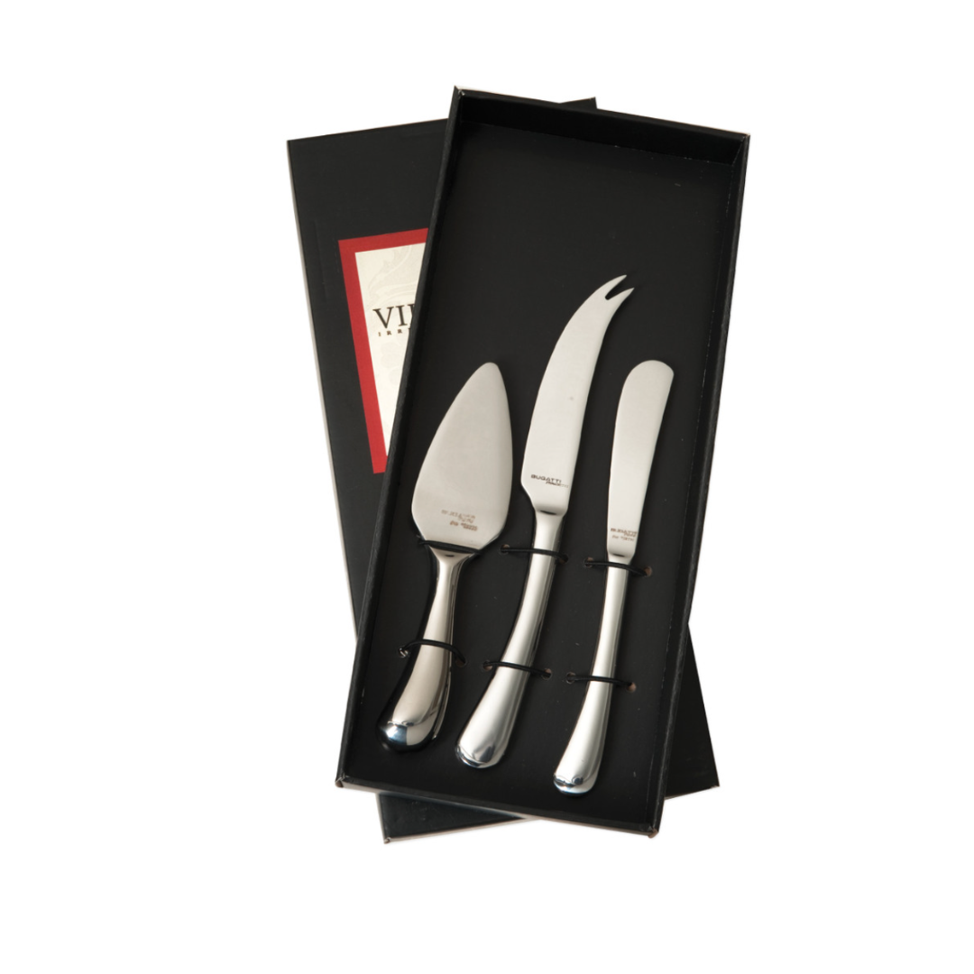 The Casa Bugatti Settimocielo 3 Piece Cheese Knives Set includes a server, fork-tipped knife, and spreader in stainless steel, all elegantly presented in black packaging.