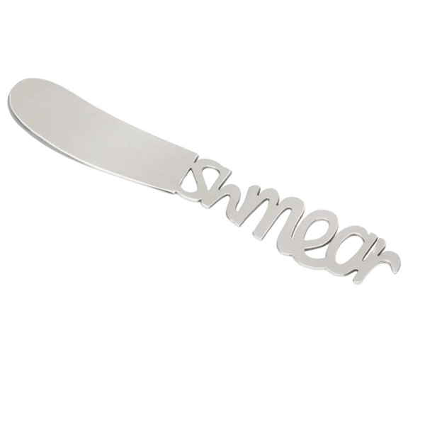 A silver Schmear Spreader knife by Inspired Generations, featuring the word “smear” cut out in the handle—perfect for adding cream cheese to your favorite bagel tray.