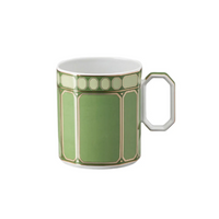 The Swarovski Signum Fern Green Mug by Swarovski x Rosenthal features a geometric green and cream Art Deco pattern and a distinctive angular handle on white porcelain—ideal as a luxury gift.