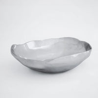 The Beatriz Ball Soho Nueve Organic Bowl 12.5" is a handcrafted, shallow bowl with a smooth, reflective silver finish. Eco-friendly and modern, it brings elegant style to any setting and looks striking against a plain white background.