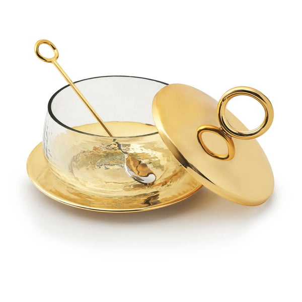The Godinger Sphere Condiment Set Gold features a stylish bowl with a hammered gold-tone base, matching lid with circular handle, small gold spoon, and coordinating plate—creating an elegant serving arrangement with the lid tilted for easy access.