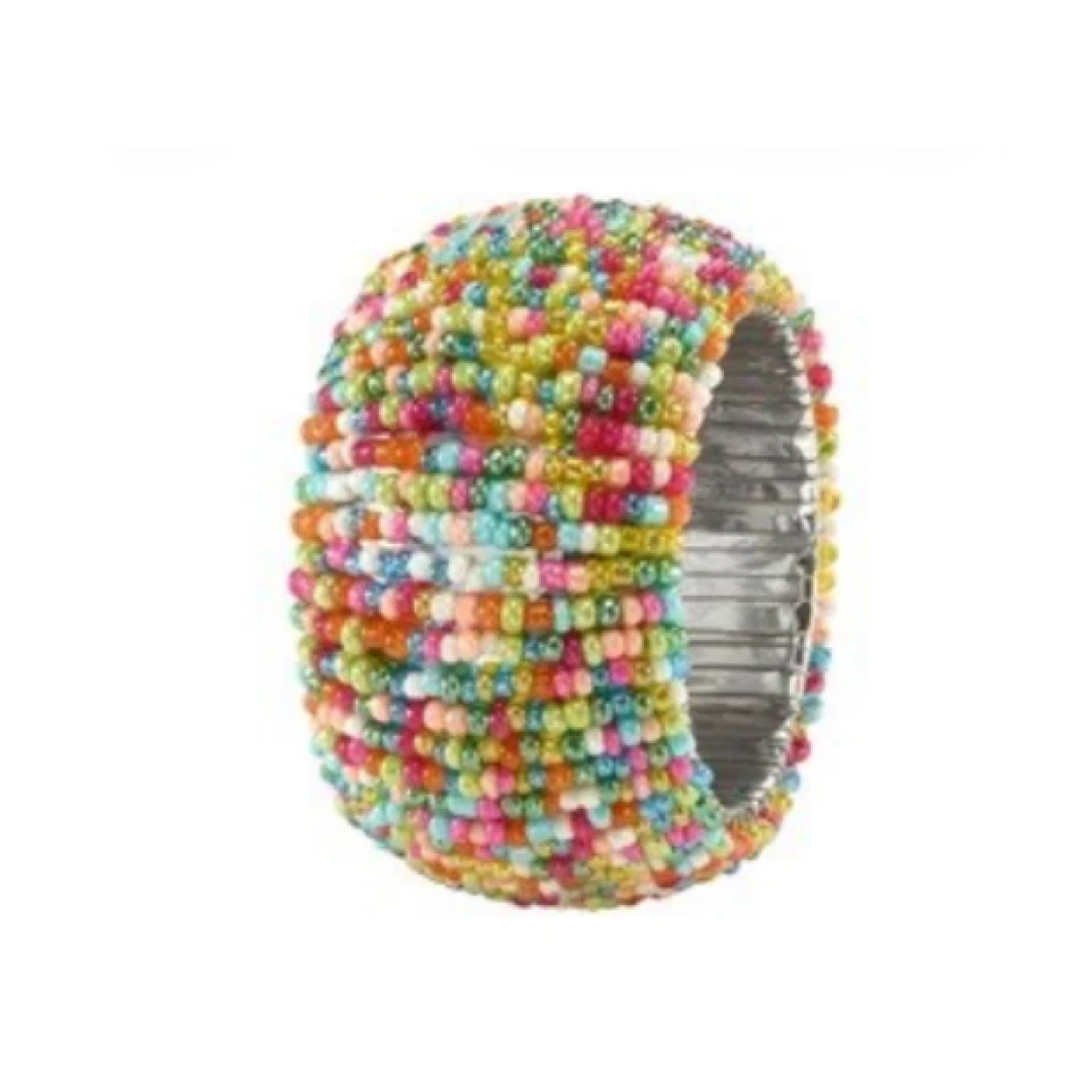 The Bodrum Candy Sprinkles Napkin Ring Set of 4 features wide, stretchy rings covered in small, multicolored beads on a silver base—perfect for adding a pop of color to your festive table setting.