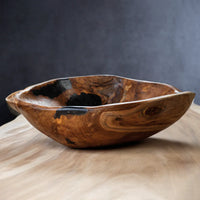The Zodax Kenya Teakwood Bowl - 20" features a handcrafted, rustic design with natural, uneven edges and dark resin accents—perfect as home décor or a decorative fruit bowl on any light wooden surface.