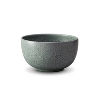 A round, green speckled ceramic bowl from the L'Objet Terra Seafoam Dinnerware collection, handcrafted and shown on a plain white background.