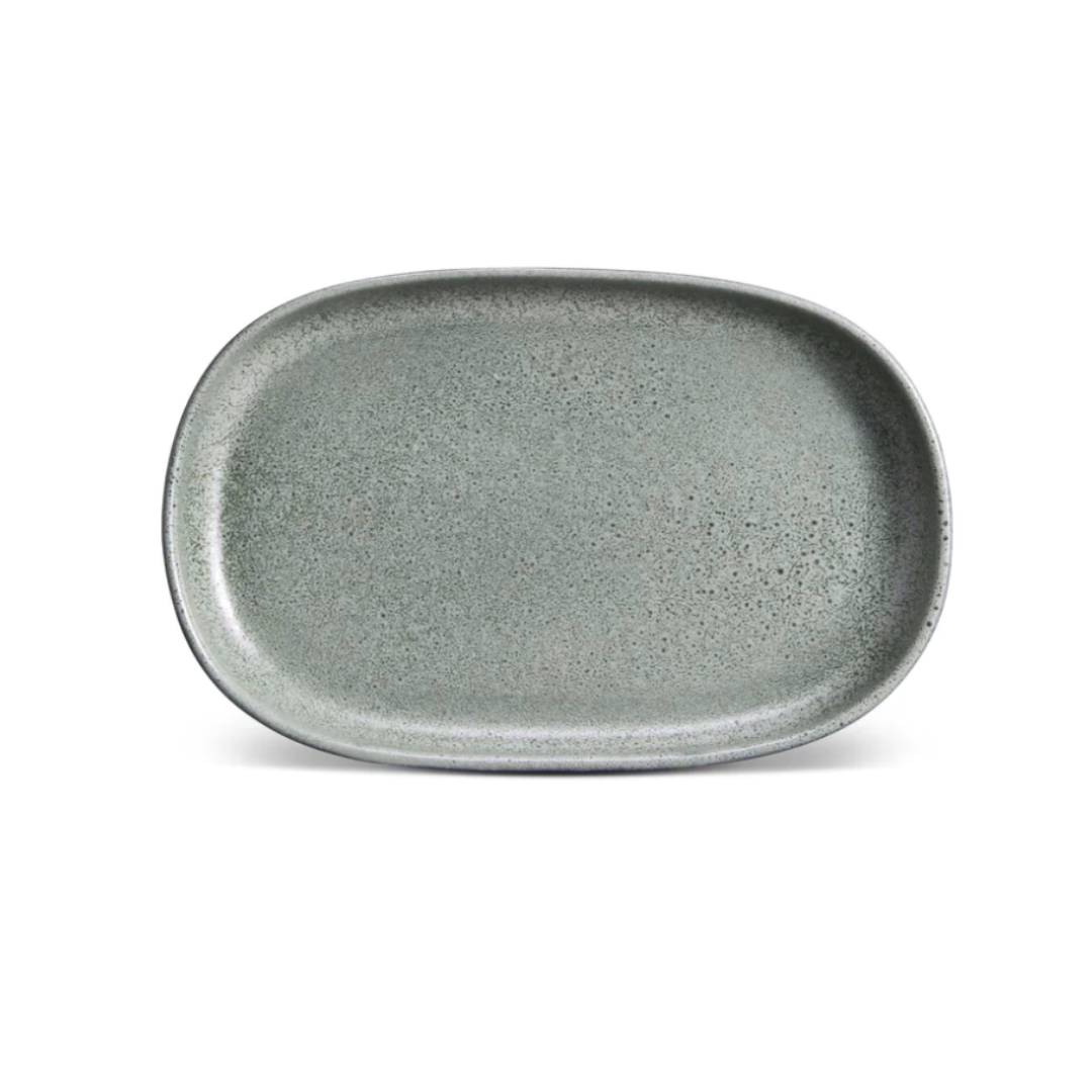 The L'Objet Terra Seafoam Dinnerware is a handcrafted, rectangular ceramic plate in shallow gray-green with rounded edges and a speckled finish, shown on a white background.