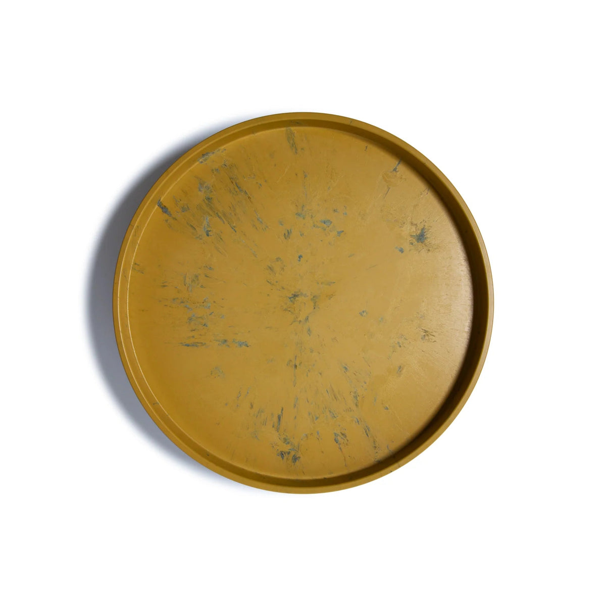 The Smart Lazy Susan by Trashy Goods is a round, upcycled organizer tray in mustard yellow with blue-green speckled marbling, raised edges, and shown against a white background.