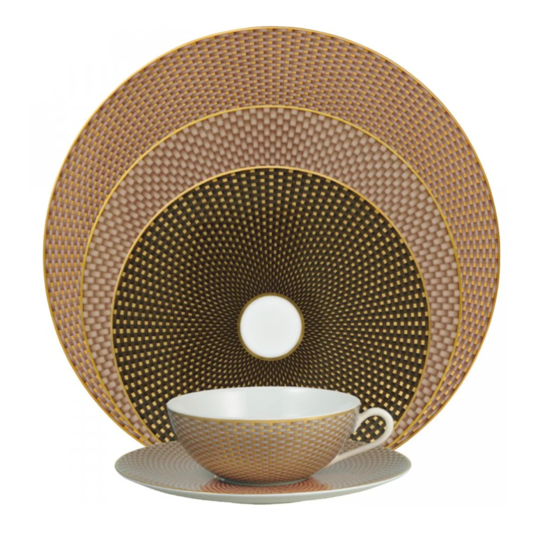 The Tresor Dinnerware Brown by Raynaud is a four-piece set—cup, saucer, salad plate, and dinner plate—featuring intricate gold, brown, and beige geometric patterns with gold rims for a touch of formal elegance.