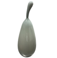 The Volume Vessel Dove Grey by Tyler Barry Design is a smooth, glossy handblown glass sculpture with an elongated, curved stem, serving as a striking sculptural accent against a plain white background.
