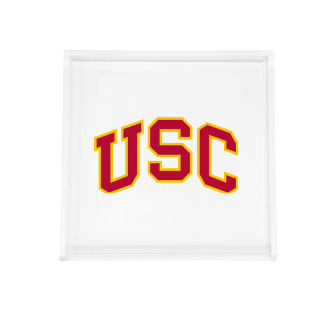 The Eye Candy College Acrylic Catchall Tray features a clear rectangular design with bold yellow USC letters outlined in red on a white base—an ideal, stylish accessory for any dorm room.