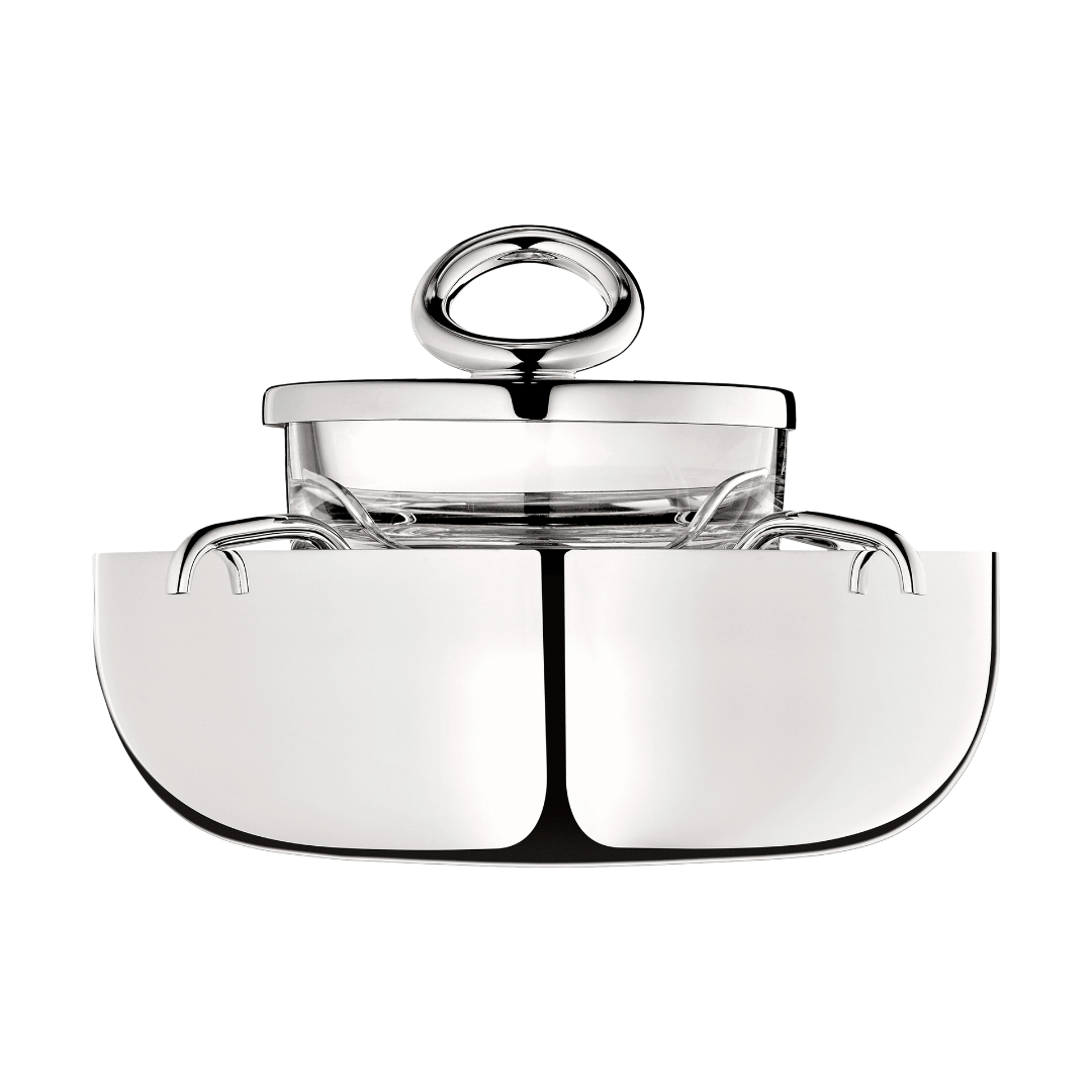 The Christofle Vertigo Silver Plated Caviar Set features a modern, minimalistic design with a polished silver finish, transparent glass section, and signature circular handle inspired by Andrée Putman's iconic Vertigo pattern.