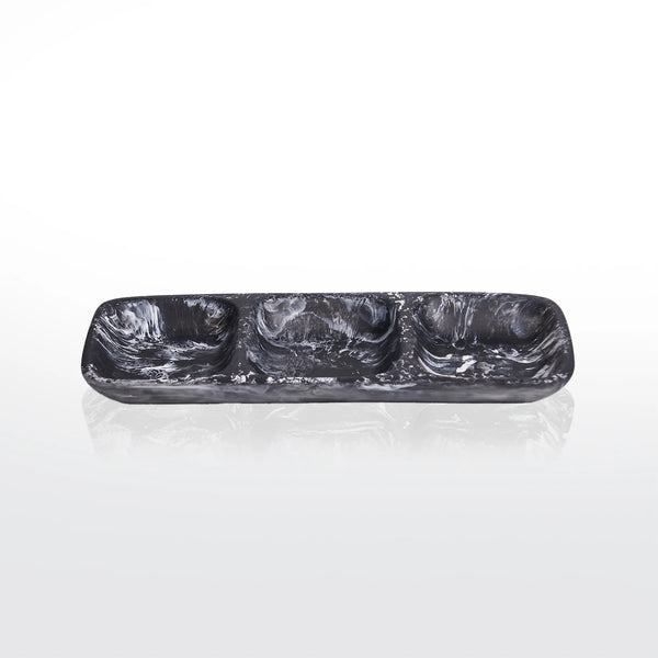 The Nashi Home Swirl Resin Classic 3 Section Tray features a rectangular black and white marbled design, three compartments, and is crafted from shatter-resistant, food-safe resin. Shown on a reflective white surface with a simple backdrop.
