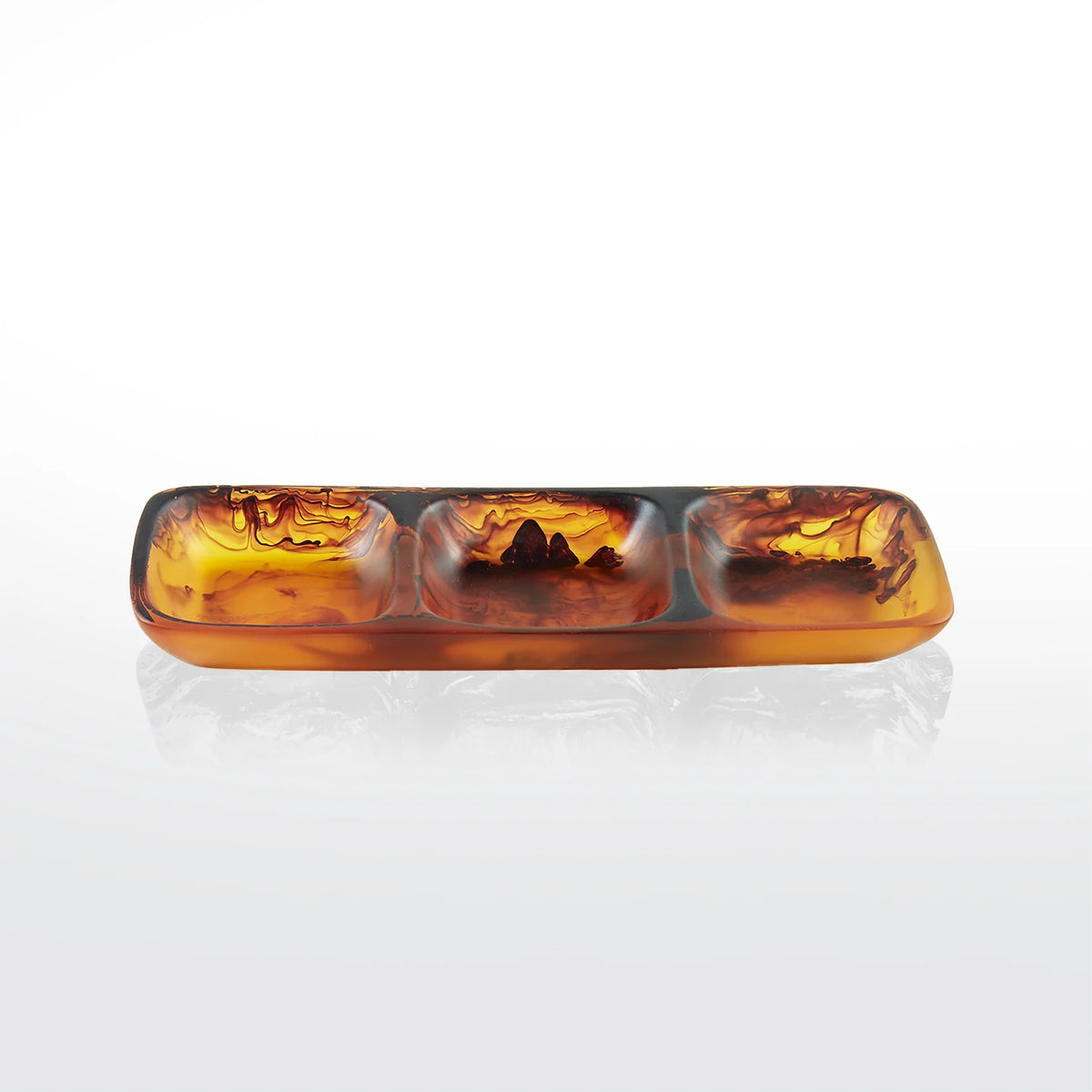 Nashi Home Swirl Resin Colored 3 Section Tray, featuring translucent amber and brown marbled swirls, is displayed on a white reflective surface.
